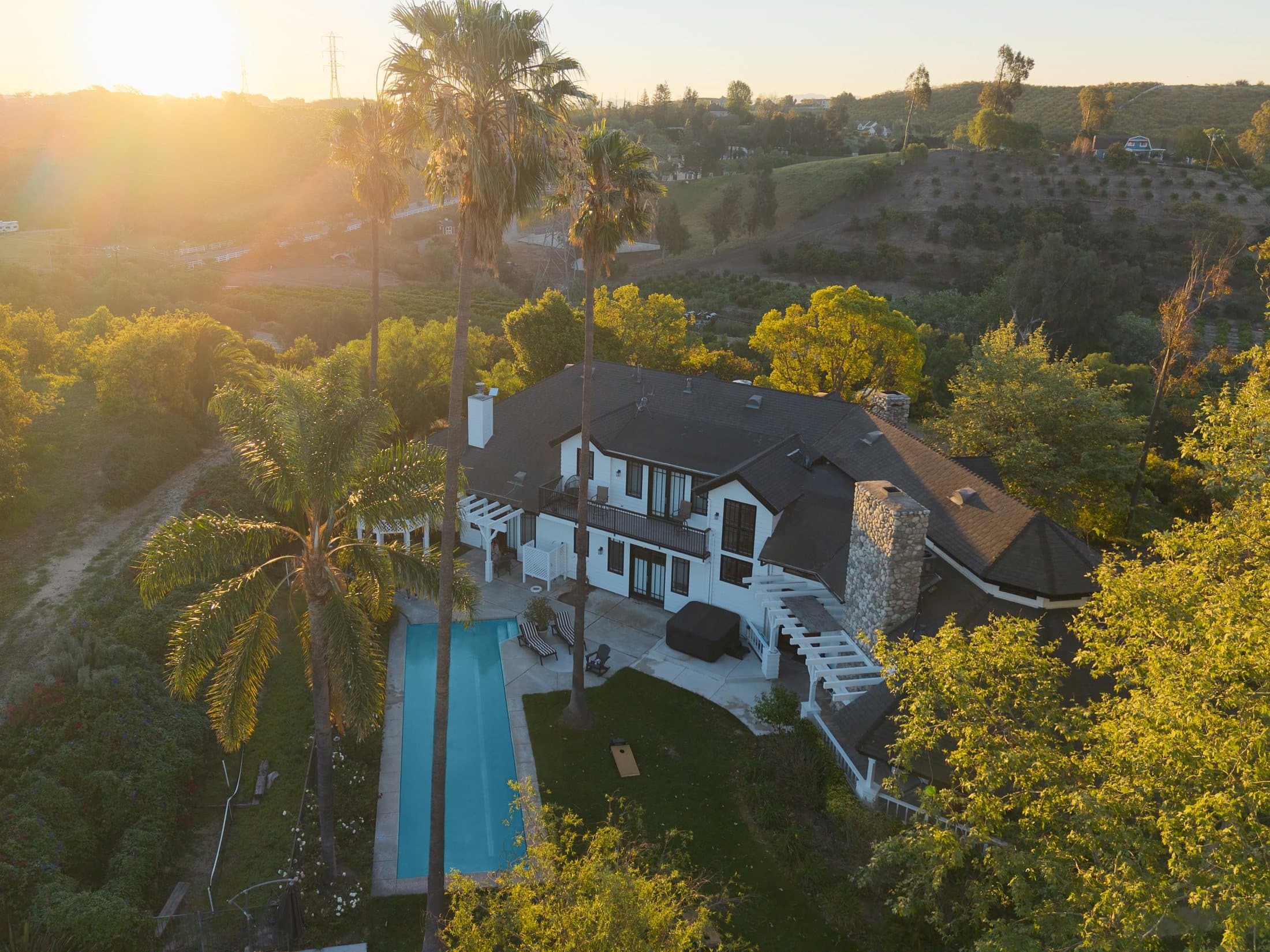 Golden-hour aerial of the Grata Ranch residence and pool