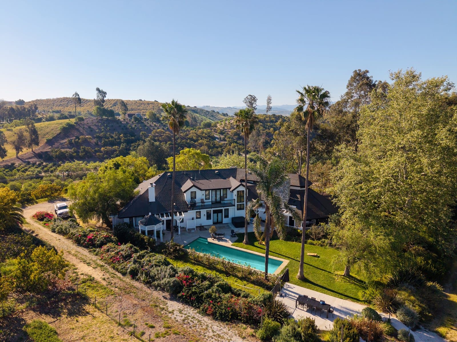 Wide aerial showing the ranch residence, pool, hills, and grounds